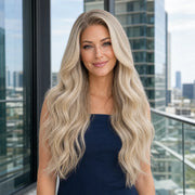 Woman wearing the Hugyoo Luxe Blonde Loose Wave glueless human hair wig in a lifestyle setting.