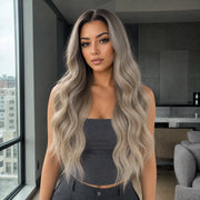 Eine Frau trägt die HUGYOO Echthaarperücke „Dark Root Ash Blonde Loose Wave“ für Halt ohne Kleber in einer Alltagsszene.