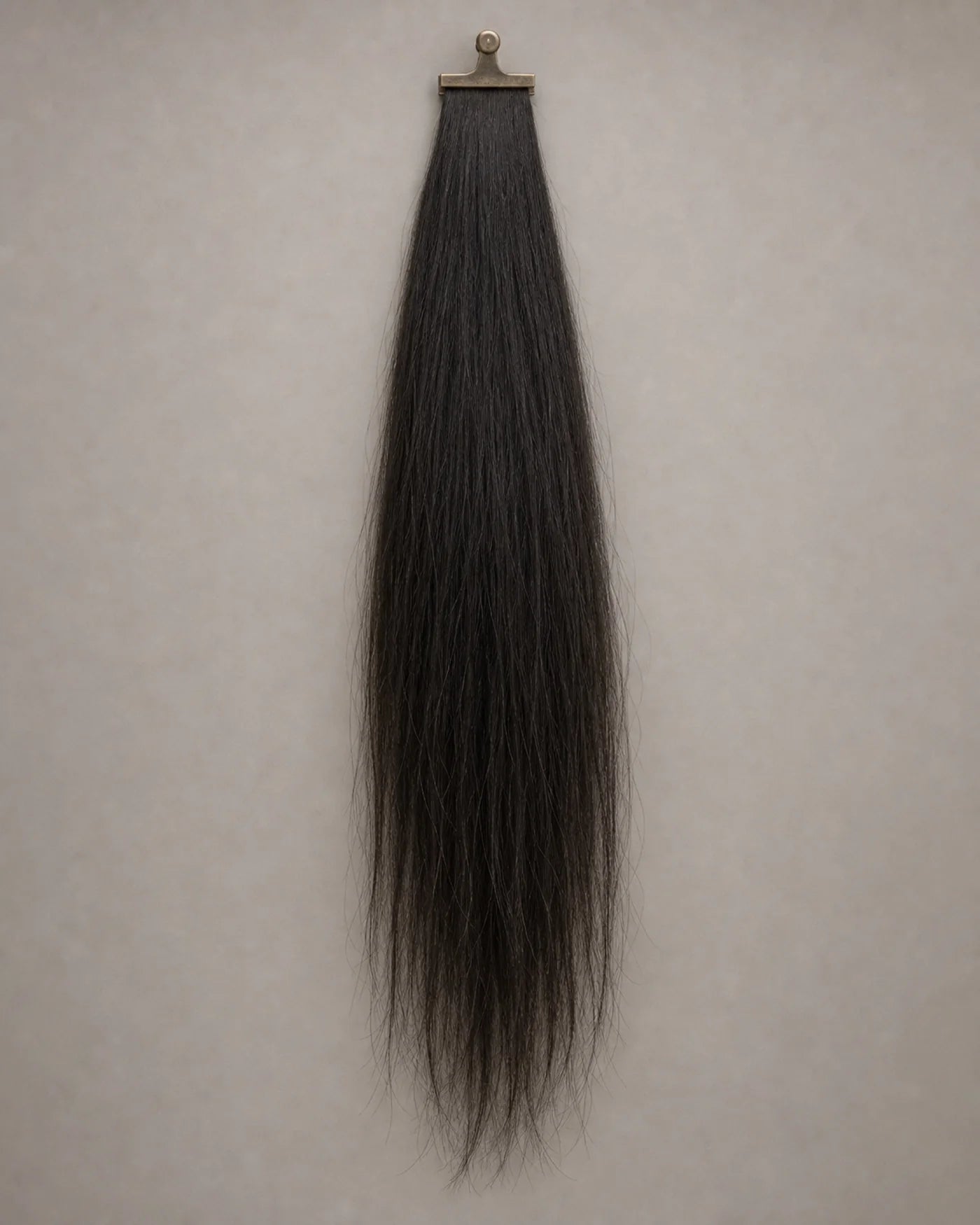 Long natural-black hair sample maintains balanced fullness from the upper lengths through the ends.
