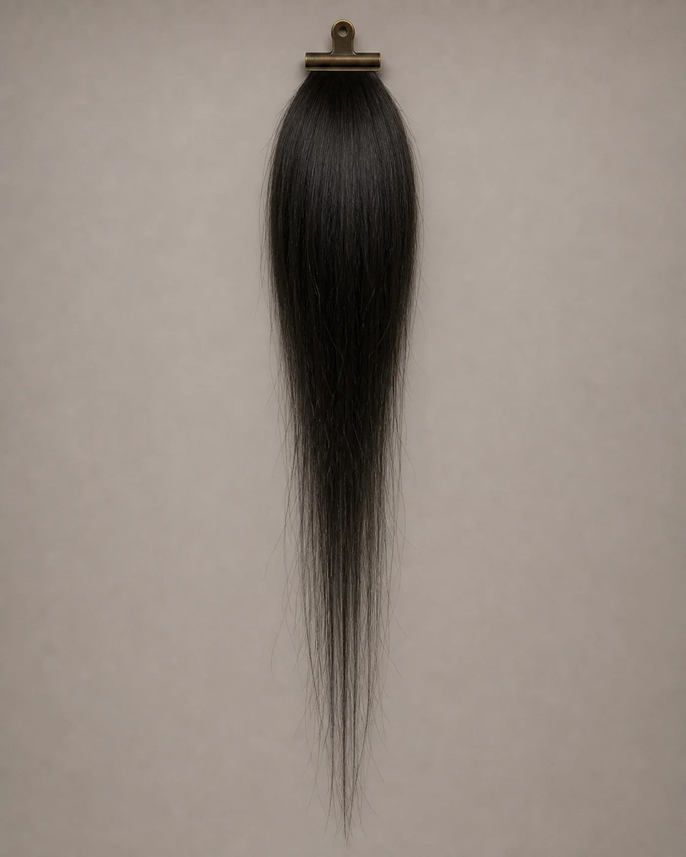 Long natural-black hair sample appears fuller near the top and visibly thinner toward the ends.