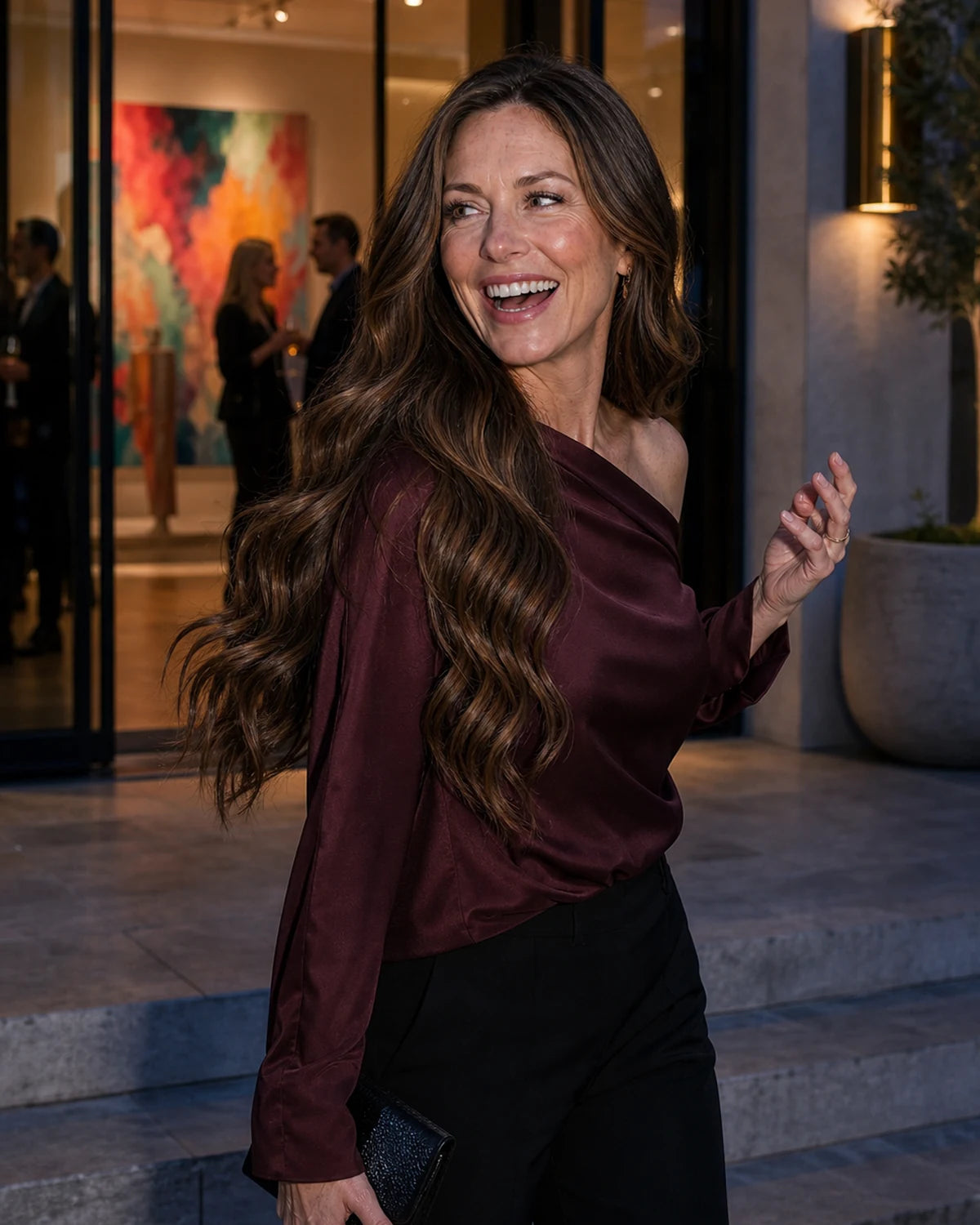 Woman with long dimensional brunette waves arriving at an evening gallery for the Hugyoo Event Ready wig edit.